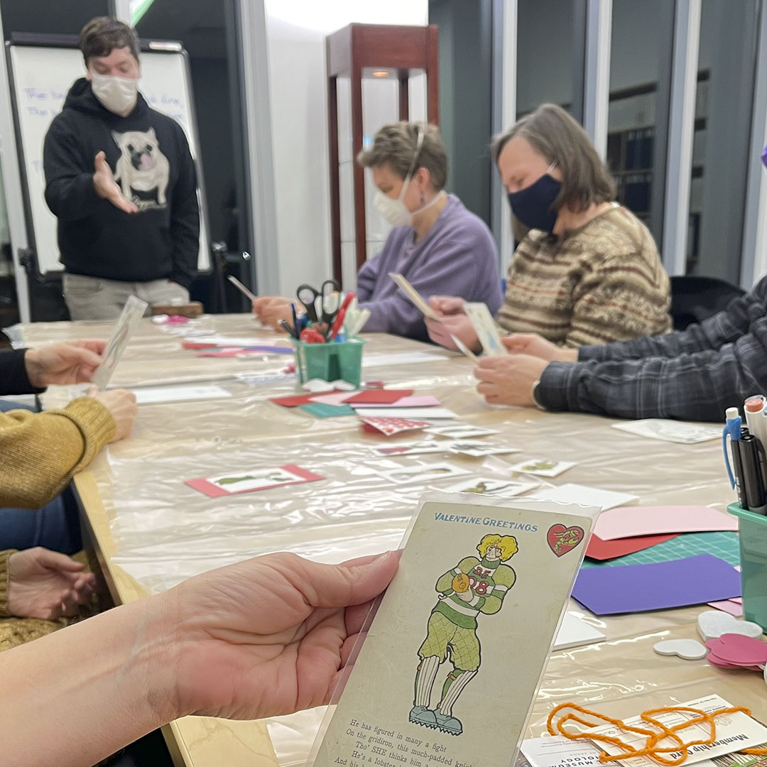 People sitting around a table examining postcards